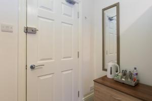 a bathroom with a white door and a mirror at Townhouse @ Balliol Street Stoke in Stoke on Trent