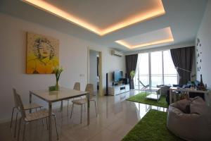 Cozy Residence Melaka في ميلاكا: غرفة معيشة مع طاولة وكراسي في غرفة