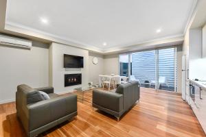 a living room with two couches and a fireplace at Aloha Central Luxury Apartments in Mount Gambier