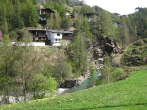 a house on the side of a hill next to a river at Ferienhaus Anna in Sölden