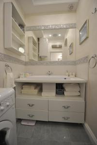 een witte badkamer met een wastafel en een spiegel bij Margot Luxury Studio in Belgrado +30 foto's