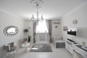een witte woonkamer met een bank en een tv bij Margot Luxury Studio in Belgrado