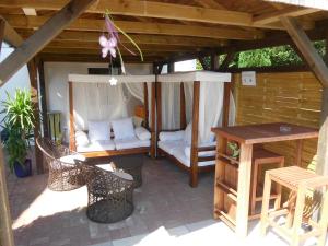 a gazebo with a porch with a table and chairs at Villa Vogelsang VV, Schwimmbad, Sauna in Sierksdorf