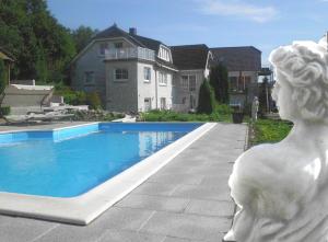 a statue of a woman standing next to a swimming pool at Villa Vogelsang VV, Schwimmbad, Sauna in Sierksdorf
