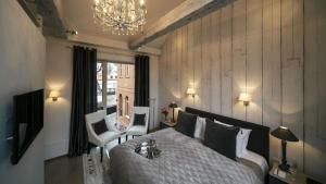 a bedroom with a large bed and a chandelier at Frost Boutique Hotel in Pärnu