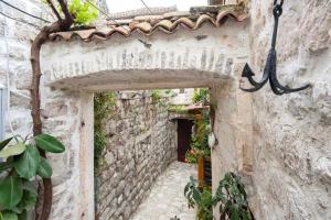 een steegje in een oud stenen gebouw met een deuropening bij Bluemarine Rooms & Apartments in Perast