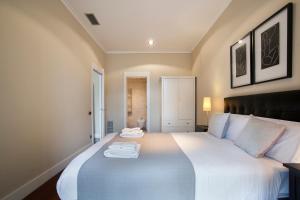 a bedroom with a large white bed with two towels on it at Tendency Rambla Catalunya in Barcelona