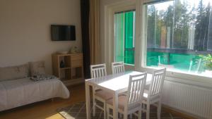 un soggiorno con tavolo, sedie e finestra di Pähkinäpuisto Apartments a Tampere