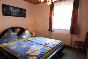 a bedroom with a bed with blue sheets and a window at Apartments Rügen Patzig in Patzig