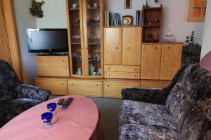 a living room with two chairs and a table and a tv at Apartments Rügen Patzig in Patzig