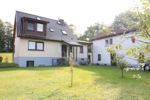 a white house with a small tree in the yard at Apartments Rügen Patzig in Patzig