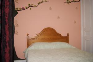 a bed with a wooden headboard in a bedroom at Azores Dream Hostel in Ponta Delgada