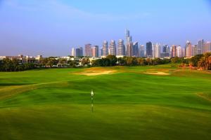 a golf course with a view of the city at Address Montgomerie in Dubai