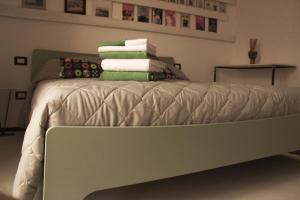 a bed with a pile of towels on it at Ananke B&B in Bisceglie