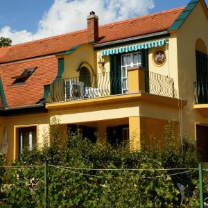 バラトンフレドにあるVilla Zsófiaのバルコニー付きの大きな黄色の家