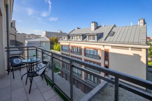 a balcony with a table and chairs on a building at Arianska Residence in Kraków