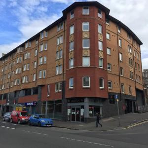 een groot bakstenen gebouw op de hoek van een straat bij The Botanic Hub West End - 2 Bedrooms in Glasgow