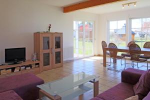 a living room with a couch and a tv at Ferienhaus Lüßvitz in Ummanz