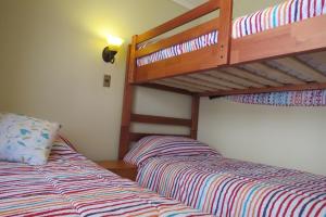 1 dormitorio con 2 camas y 1 litera en Cabañas Vikurayen, en Olmué