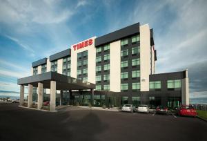 un bâtiment avec des voitures garées dans un parking dans l'établissement Grand Times Hotel, à Québec