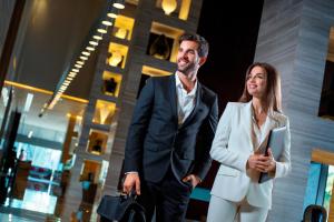 a man and a woman walking in front of a building at Capital Centre Arjaan by Rotana in Abu Dhabi