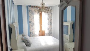 a bedroom with a white bed and a mirror at La Casa de Begoña in Laguardia