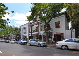 une rue avec des voitures garées devant un bâtiment dans l'établissement Eikehoff Apartments, à Stellenbosch