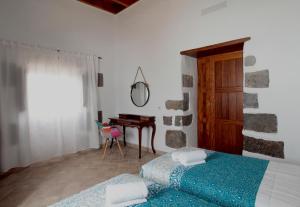 a bedroom with two beds and a table and a mirror at CASERÍO LEANDRO I in Tías