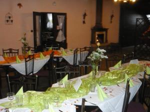 a group of tables with green napkins and flowers on them at Penzion Hamrovka in Dobřív