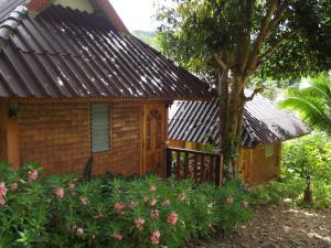 una pequeña casa con un árbol delante en Phuchomjan Resort, en Mae Hong Son