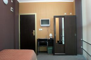 a bedroom with a bed and a desk and a television at Formula 1 Motel in Byala Ruse