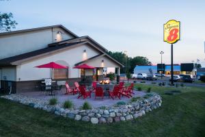 a restaurant with red chairs and a table and a sign at Super 8 by Wyndham Spirit Lake/Okoboji in Spirit Lake