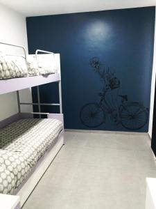 AcriにあるB&B Sandro Pertiniの壁に自転車の男性の壁画が施されたベッドルーム