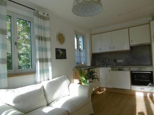 ein Wohnzimmer mit einem weißen Sofa und einer Küche in der Unterkunft Ferienwohnungen Babo 6 in Regensburg