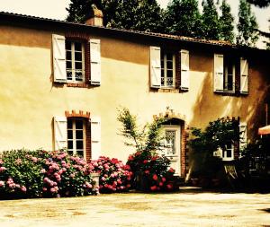 dom z kwiatami przed nim w obiekcie Relais de Chasse la Chaignaie w mieście Montaigu-Vendée