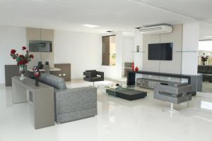 a living room with a couch and a tv at Hotel Cadori in Paiçandu