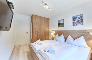 ザールバッハ・ヒンターグレムにあるAppartement Hotspotの白いベッドと薄型テレビのある寝室 +38枚の写真