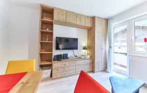 ザールバッハ・ヒンターグレムにあるAppartement Hotspotのテーブルと椅子とテレビのあるリビングルーム