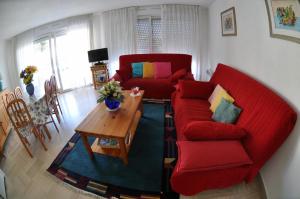 a living room with a red couch and a table at Les Pins Bleus - Antibes Juan Les Pins in Juan-les-Pins