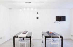 a dining room with a black table and white chairs at La Palummara in San Panfilo dʼOcre