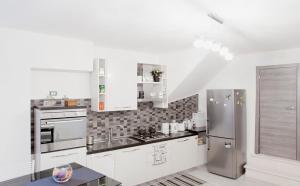 a kitchen with white cabinets and a stainless steel refrigerator at La Palummara in San Panfilo dʼOcre