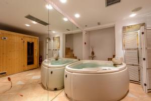 a large bathroom with a large tub and a large shower at Chora Resort Hotel & Spa in Chora Folegandros