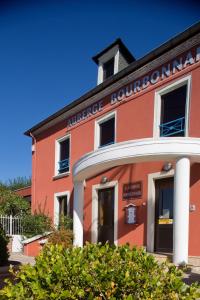 ein rotes Gebäude mit einem Schild darauf in der Unterkunft Logis L'Auberge Bourbonnaise in Saint-Yorre