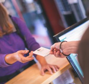 una persona che consegna una carta di credito a un'altra persona di Belfast International Youth Hostel a Belfast