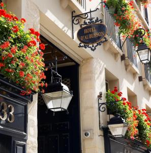 a door with flowers and a sign on a building at Hôtel D'Aubusson in Paris