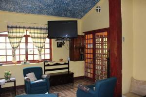 イピアバスにあるHotel Fazenda Sao Sebastiaoのリビングルーム(青い椅子、薄型テレビ付)