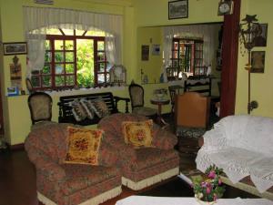 sala de estar con sofá y silla en Hotel Fazenda Sao Sebastiao, en Ipiabas