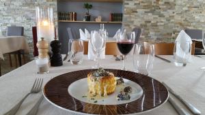 une assiette de nourriture sur une table avec des verres à vin dans l'établissement Auberge le Cheylet, à Apchon