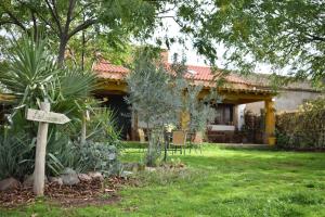 una casa con un jardín con un cartel en el patio en Casa Rural La Coscoja en Mérida