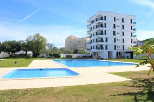 an empty swimming pool in front of a building at Vilamoura Dolphin Studio in Vilamoura